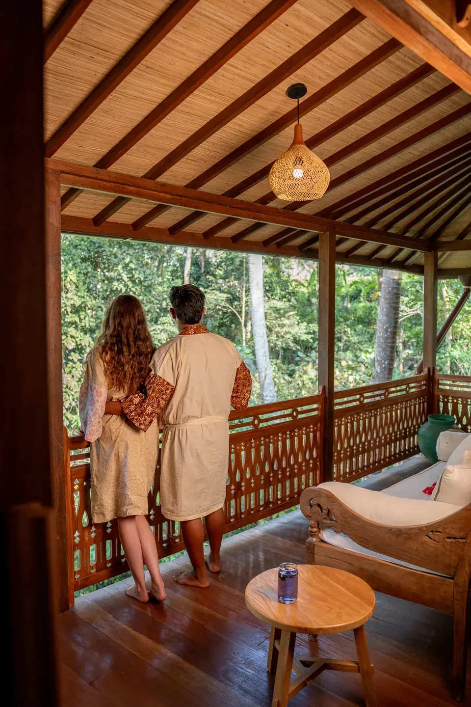 Guests looking out over the trees from a wooden verandah