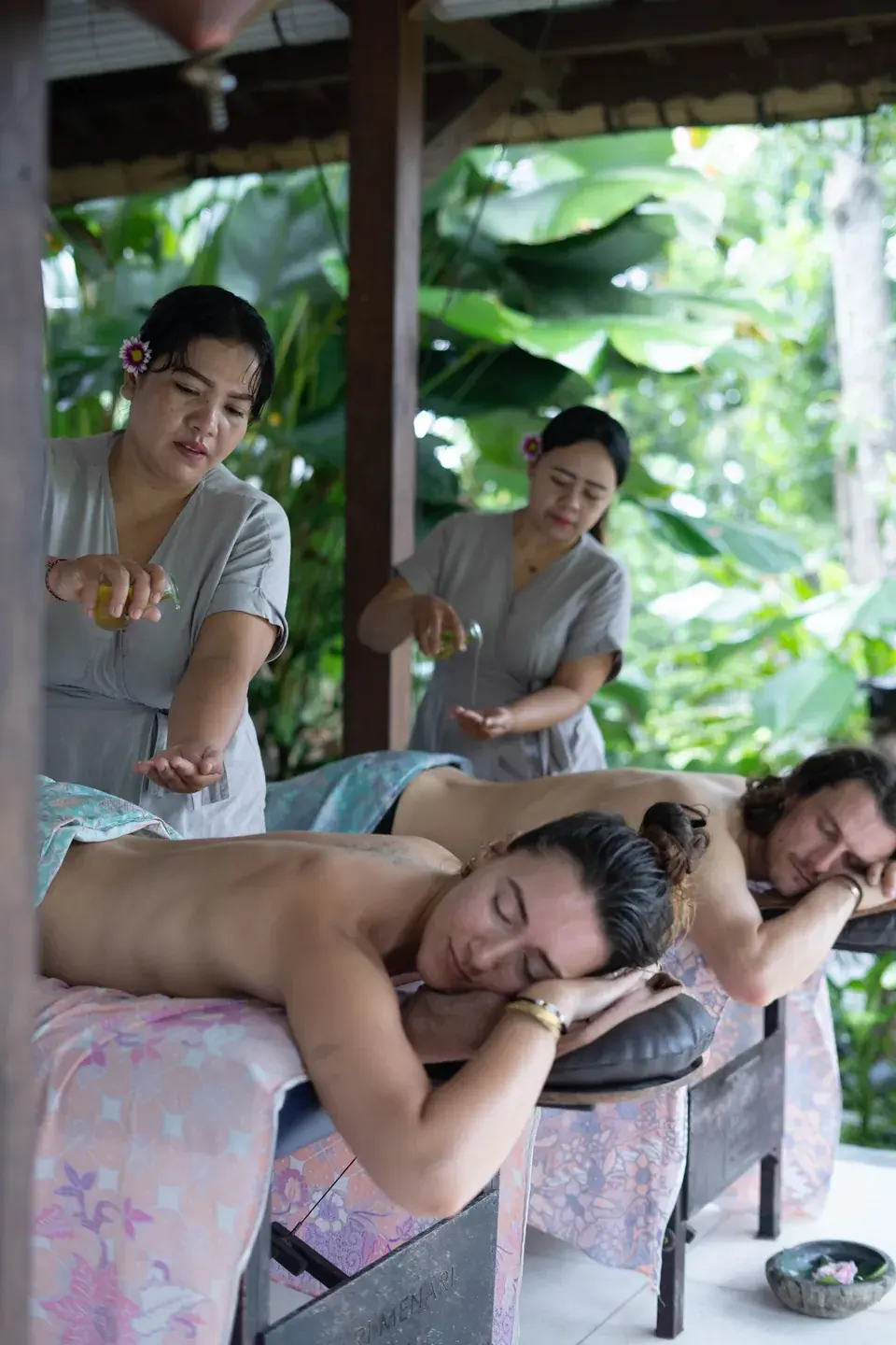 Two guests enjoying massage in the open-air pavilion
