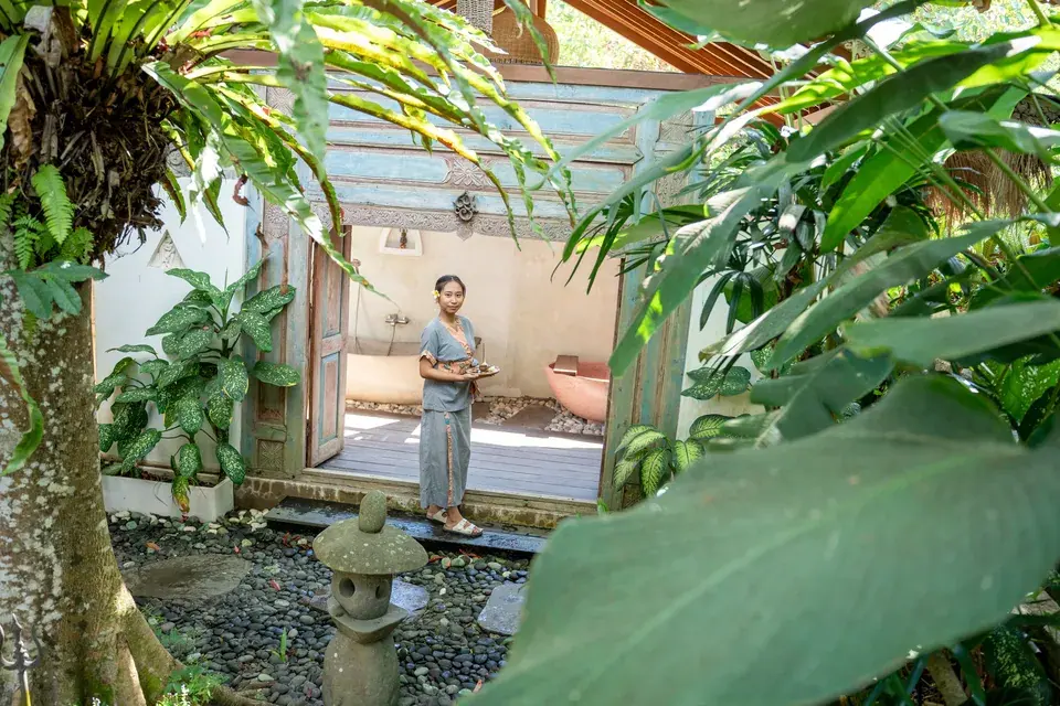 A therapist welcoming guests at the entrance to the spa bath rooms