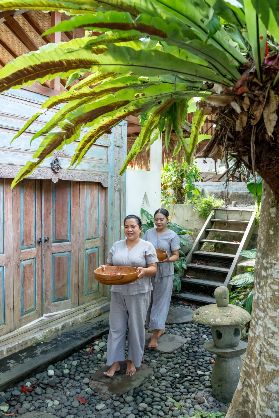 Therapists carrying a tray through the garden