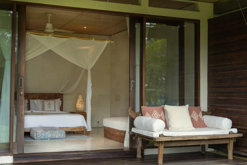 A covered verandah with a daybed and outdoor seating
