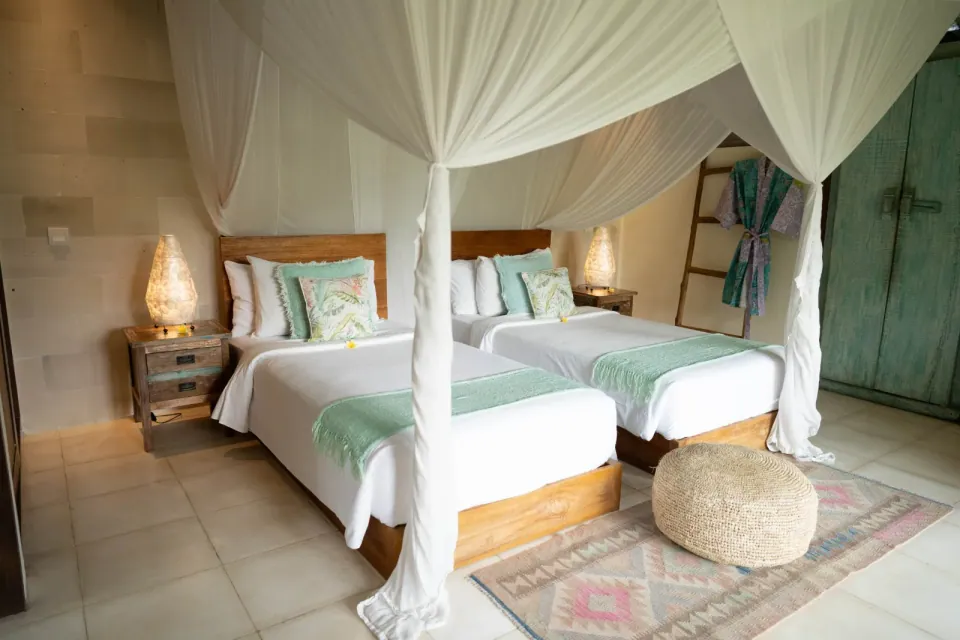 Twin beds beneath light fabric canopies